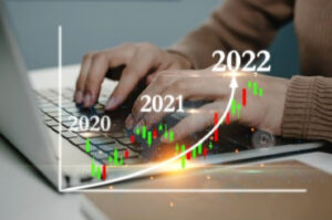 A business woman using a laptop, working on business stock growth graph.