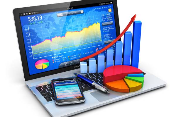 Business trading chart displayed in the Laptop screen, A pen & a mobilephone placed on left side of the laptop keyboars. A pie chart & Bar chart visualized in the leftside of the keyboard.