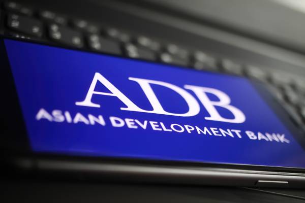 Image of a mobile phone kept above a keyboard displaying the term ADB.