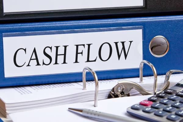 Image of a "cash flow" file kept on an open file and a calculator kept on it.