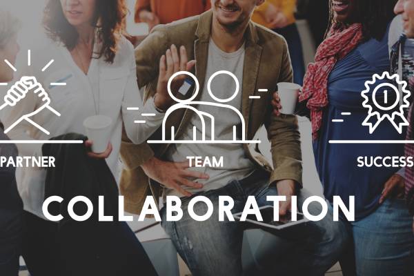 A team of businessmen joining hands together and the terms collaboration,partner,team,success etc are mentioned on a virtual screen.