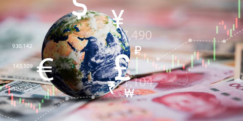 Image of globe with currency sign kept on international banknotes along with a graphical representation of trade in the background.