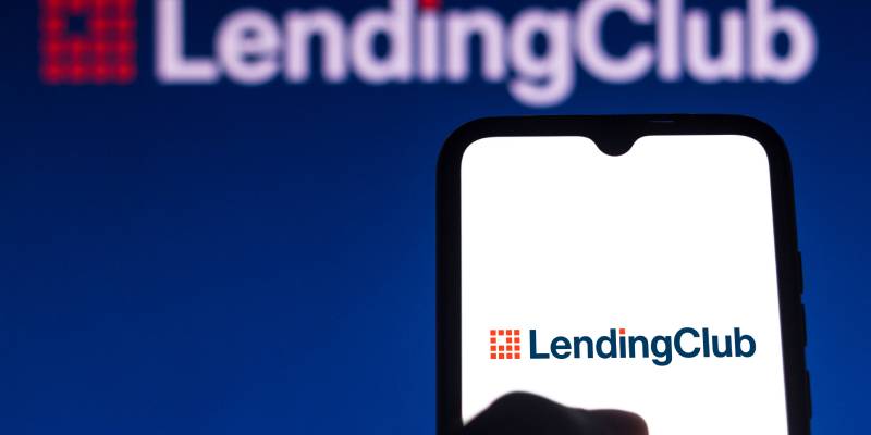 A person holding a mobile with the logo of lending club on the mobile and also in the background.