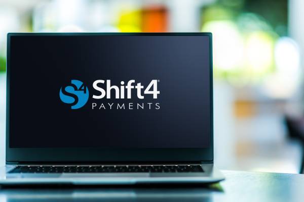 Image of a laptop displaying the logo of Shift4 Payments.