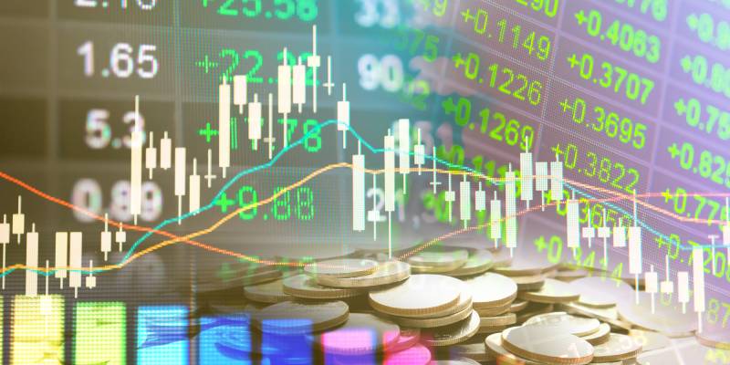 Image of finance business graph and data along with a stack of coins kept in front of it.